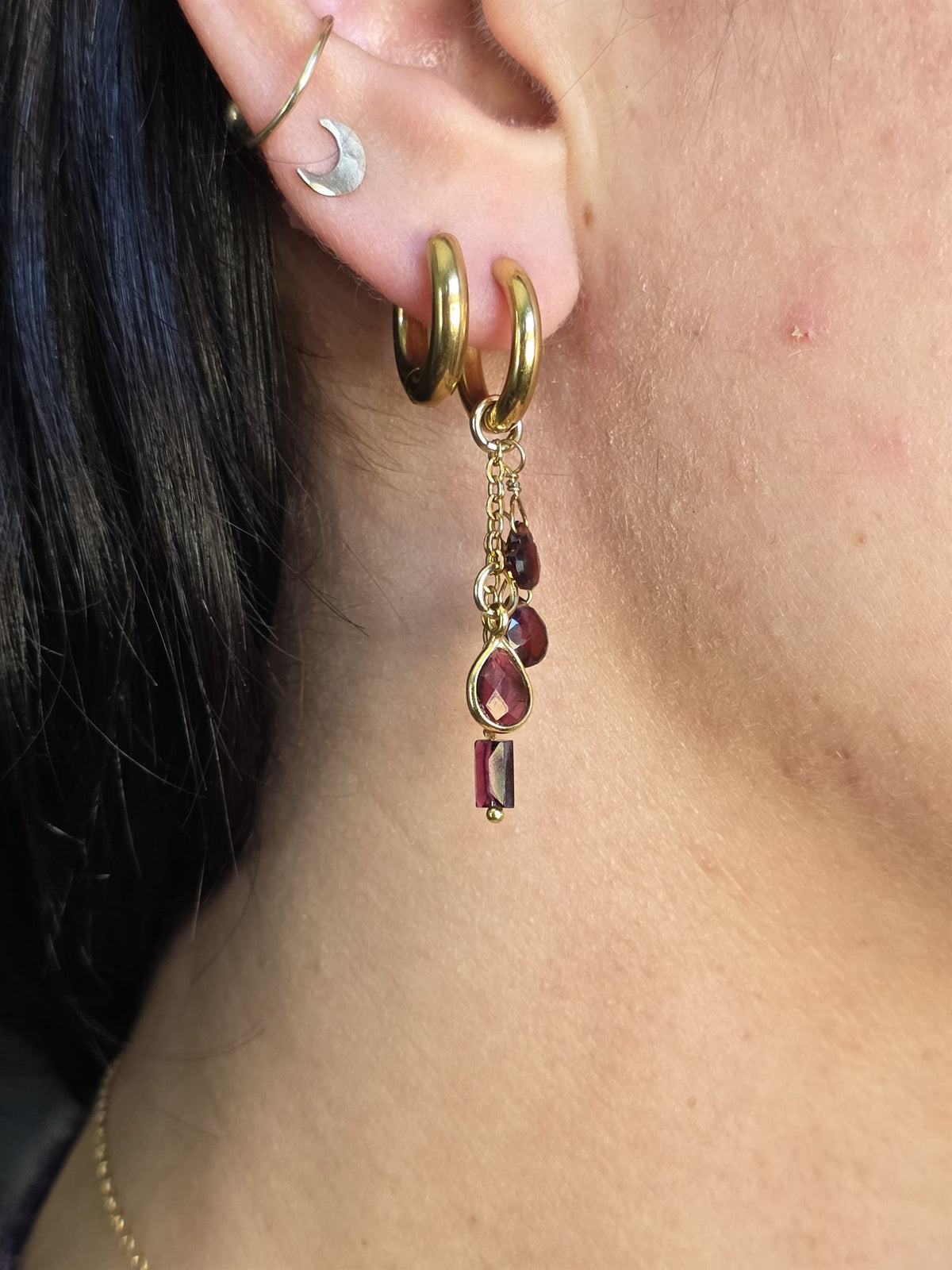 Garnet drop earring worn, close-up