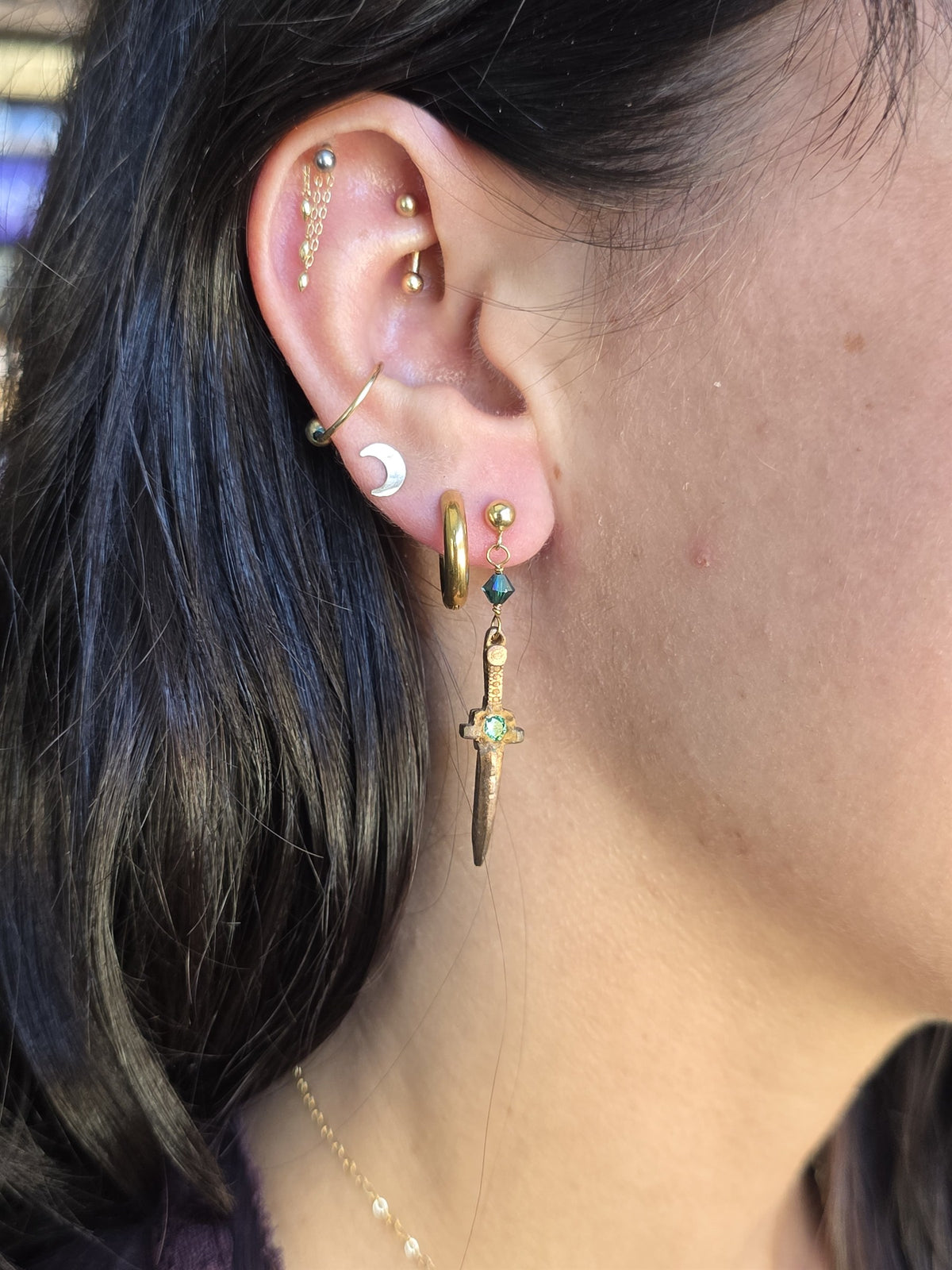 Bronze dagger earring worn, profile view